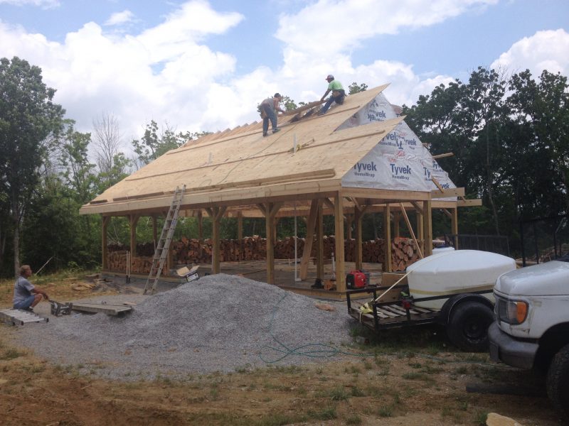 Roofers laying the plywood decking for a metal roof