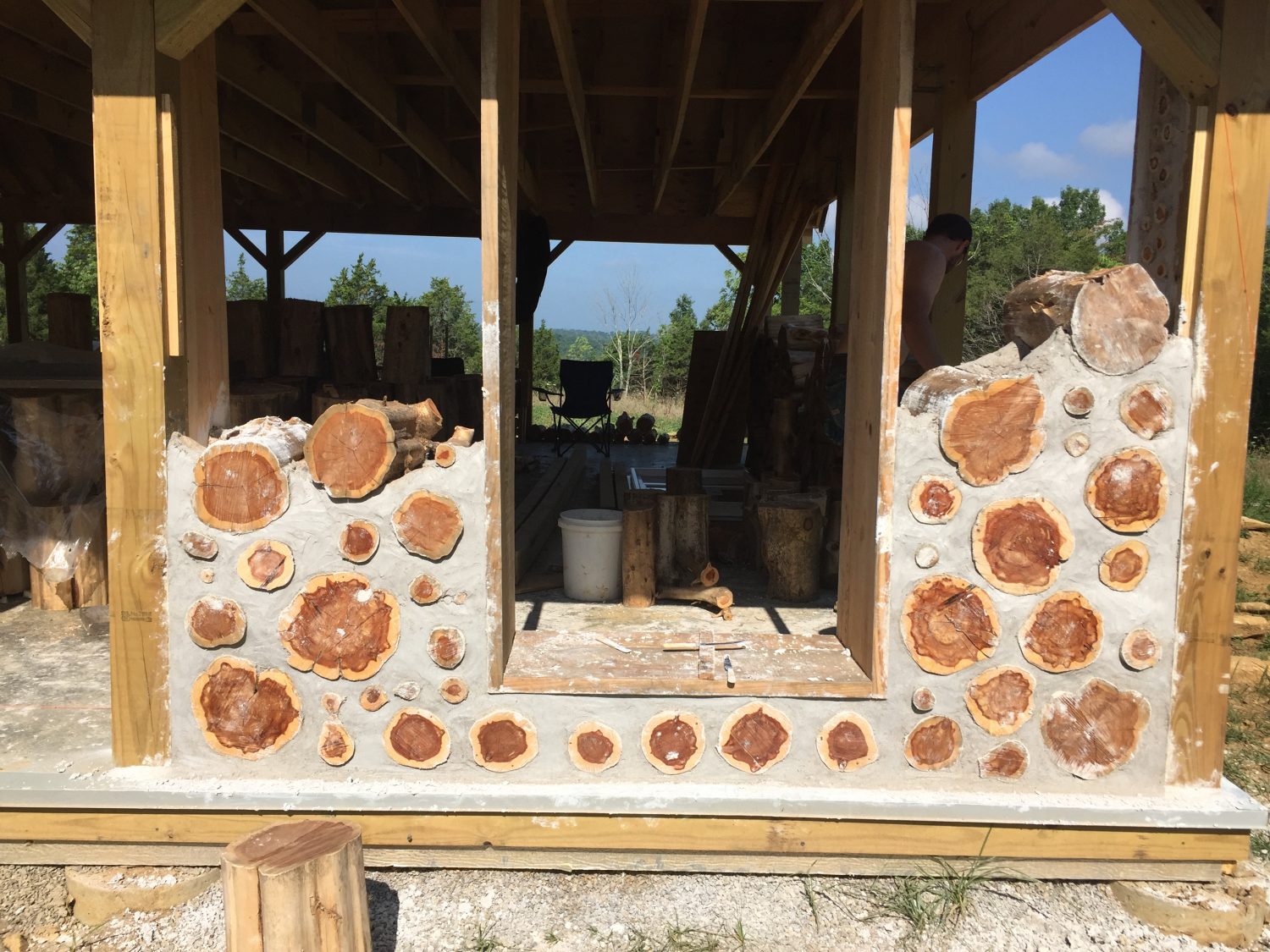 A cordwood wall in progress on a house
