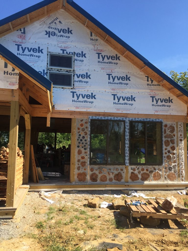 Front of a cordwood house in progress - from Accidental Hippies