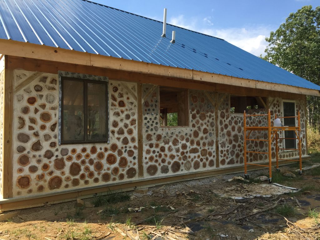 Exterior cordwood wall in progress - at Accidental Hippies