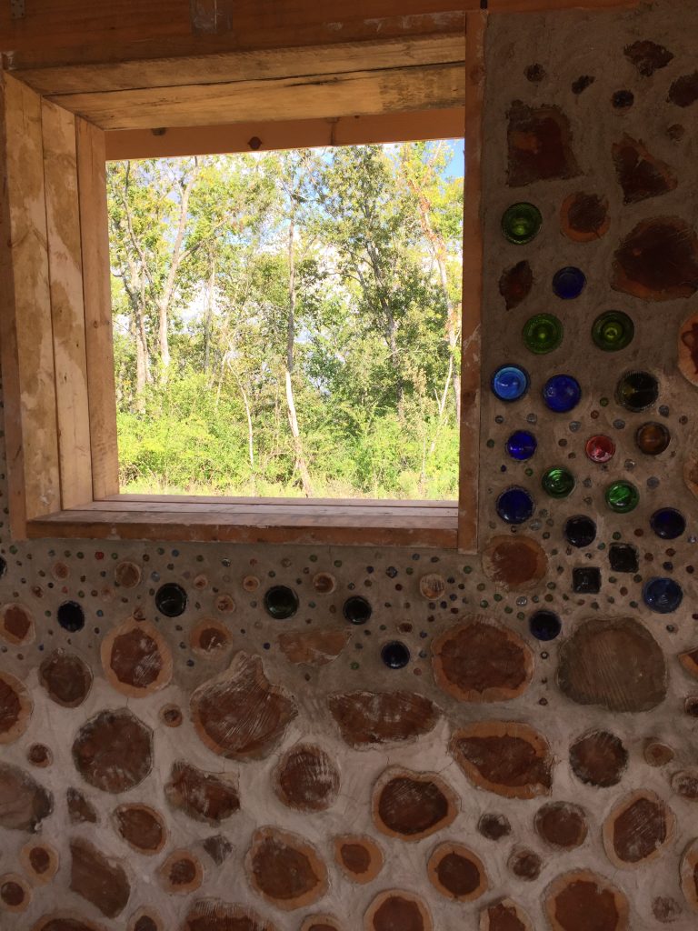 Bottles and marbles in a cordwood wall - at Accidental Hippies