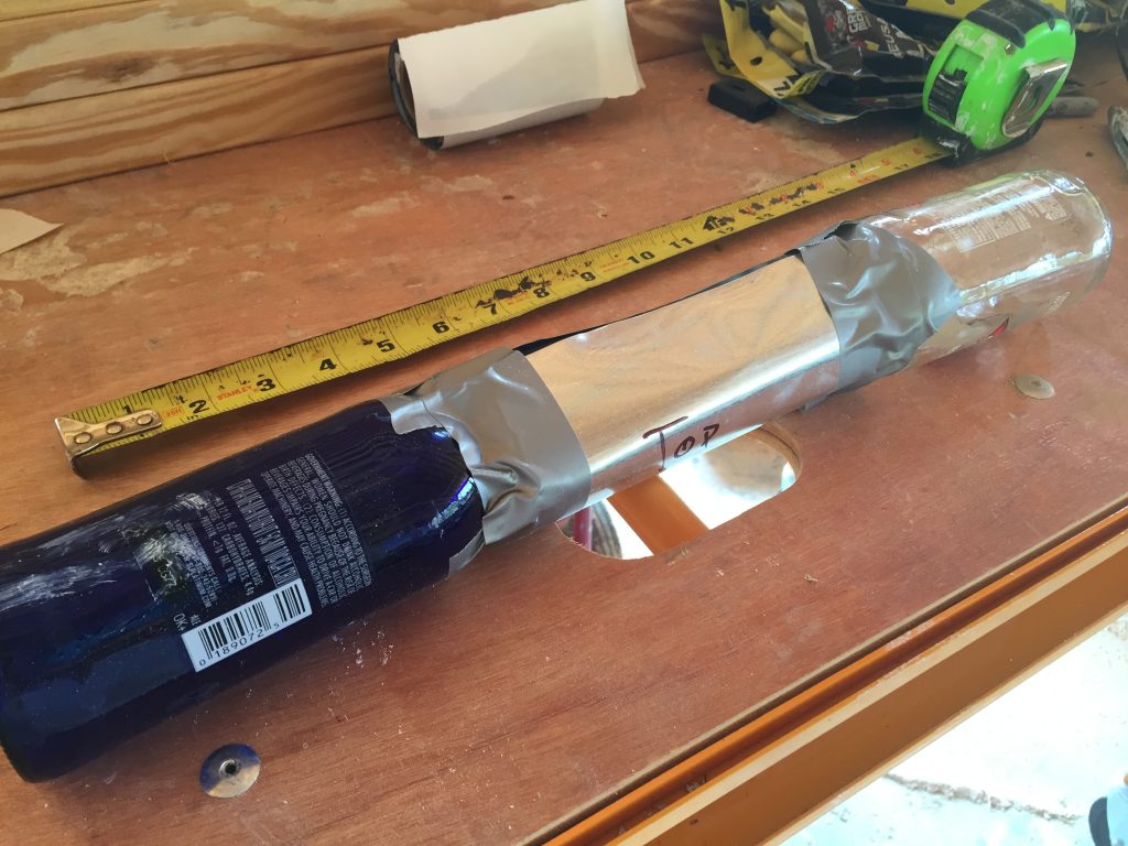 A bottle brick made out of two beer bottles joined with metal flashing and duct tape