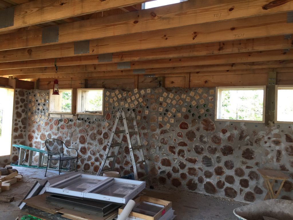A cordwood wall made with a mix of red cedar logs and white pine posts