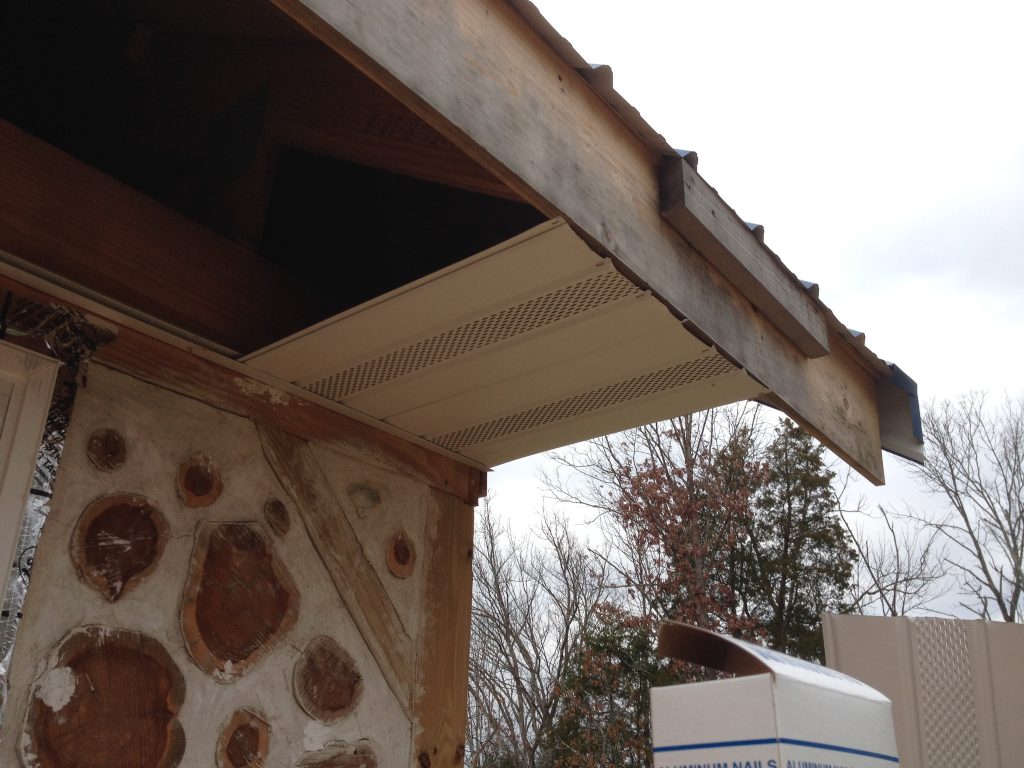 Soffit installation in progress on a cordwood house