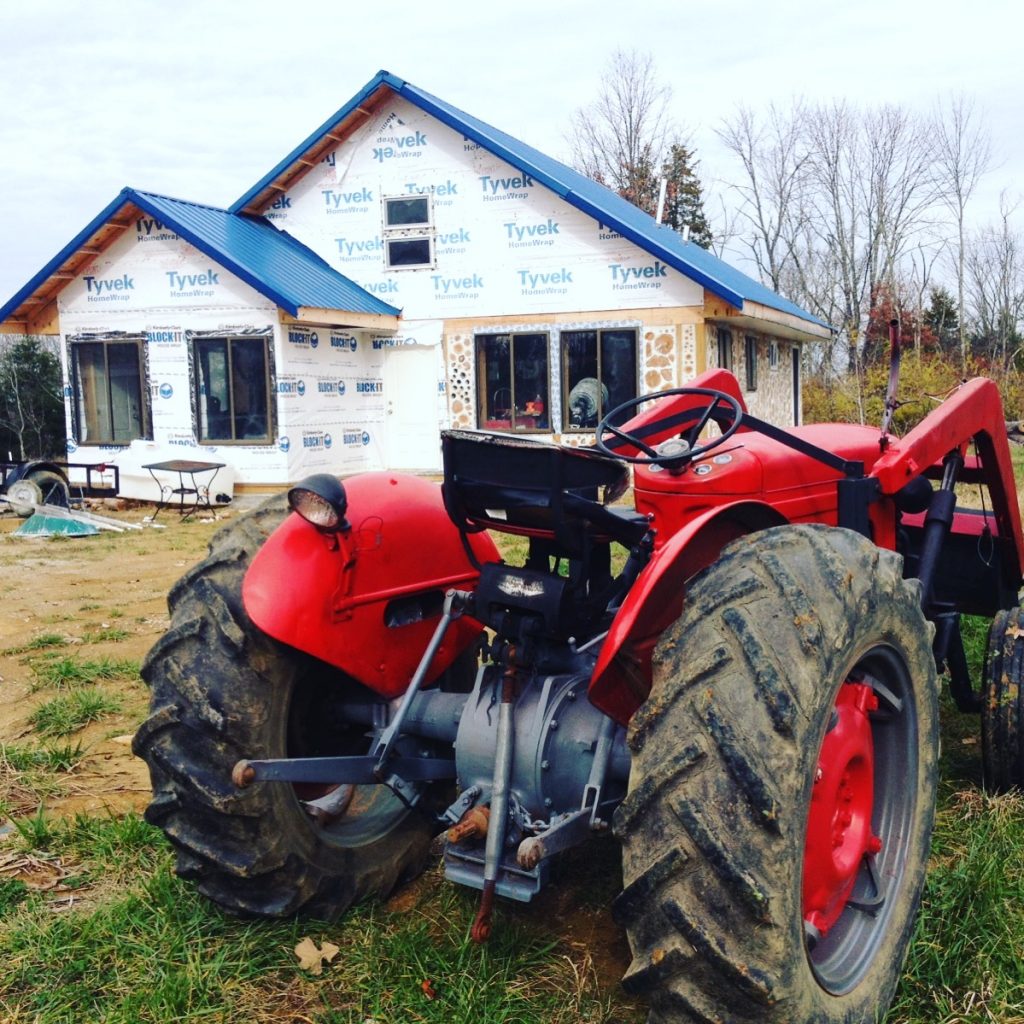 Massey Ferguson 50 in front of our cordwood house