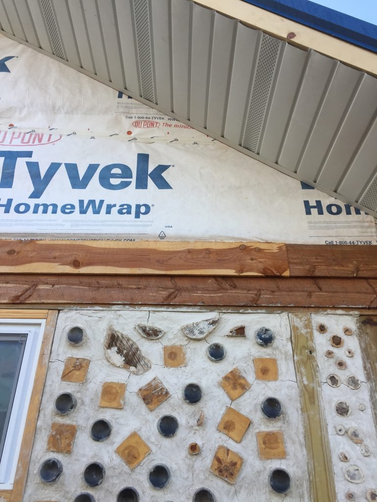 Soffit and cedar siding in progress on the gable end of our cordwood house