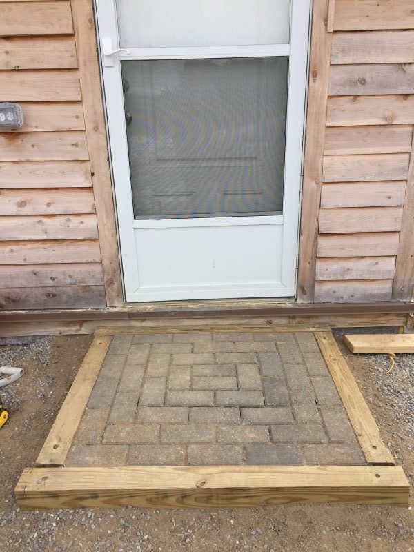 We built a simple paver step out of leftover pressure treated timbers, free paver bricks, and rebar. See more projects as we finished our cordwood house here.