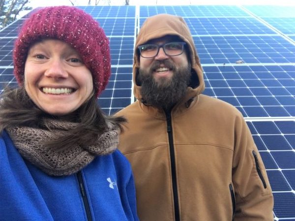 couple in front of solar panels