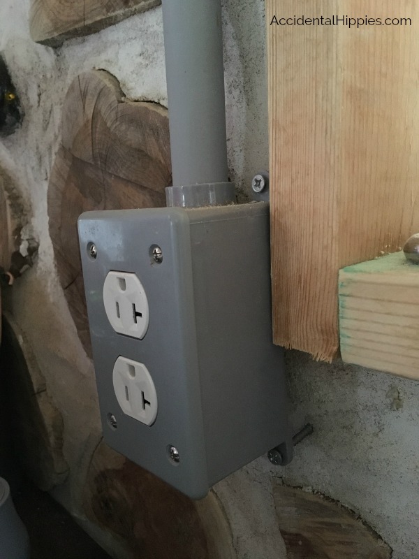 Example of a surface mounted outlet on a cordwood wall. Here's what you need to know when running electrical in or on cordwood masonry.